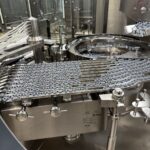 Flip-off cap elevator and feed chute of the OPTIMA VVM 2428 capping machine