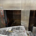 Telstar Celester autoclave with the door open and loaded carts in front of the chamber