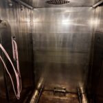 Stainless steel chamber interior of the Getinge sterilizer with cart rails and ceiling air outlet